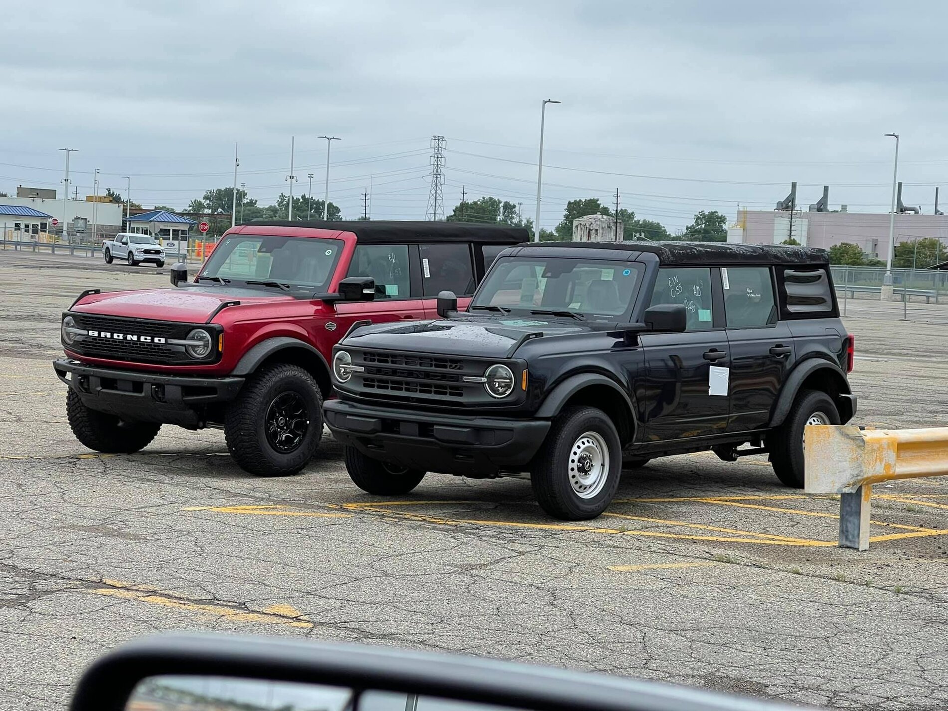 Ford Bronco Wildtrak vs Base Bronco 4-Door Side-by-Side Shows Height and Equipment Difference 2021 Bronco -- Rapid Red Wildtrak + Shadow Black Base 4-Doors 1