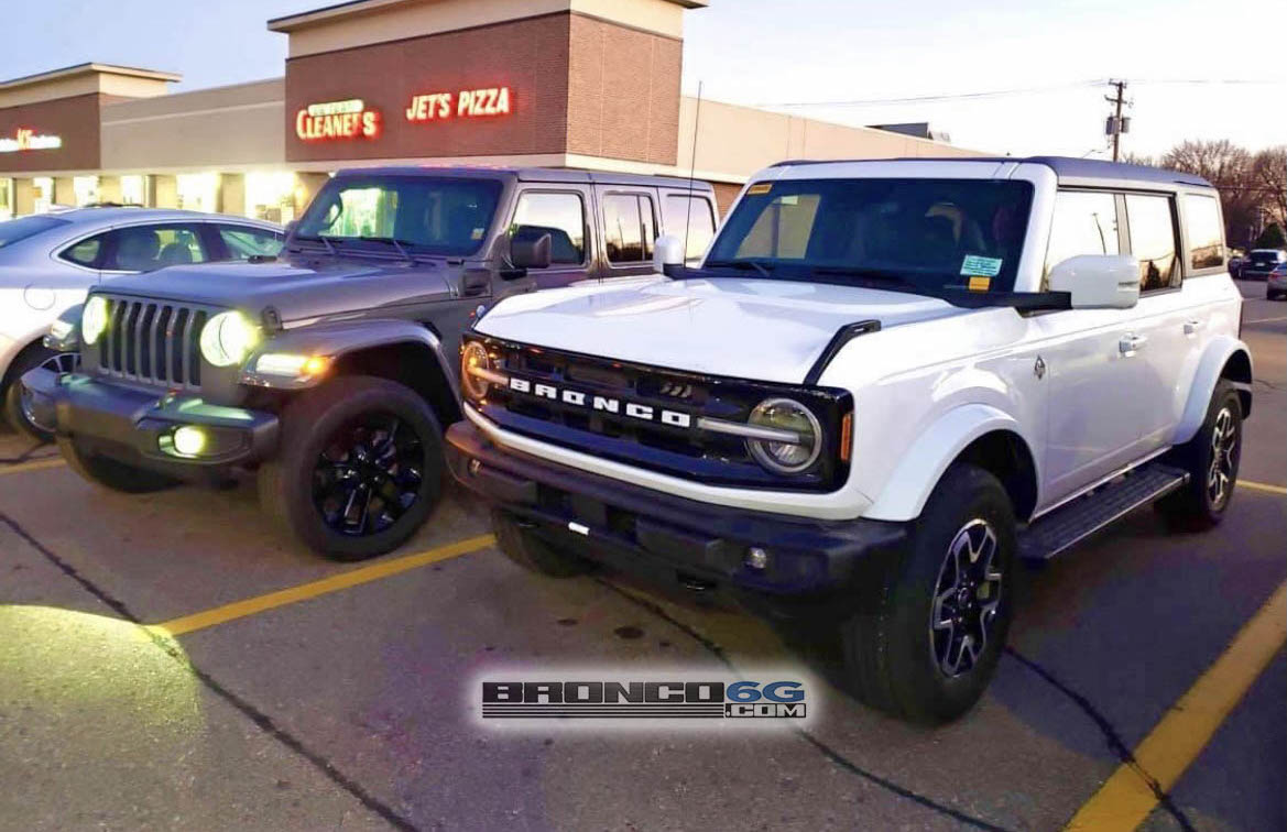 Spotted White Bronco Outer Banks next to a Wrangler 4xe Hybrid