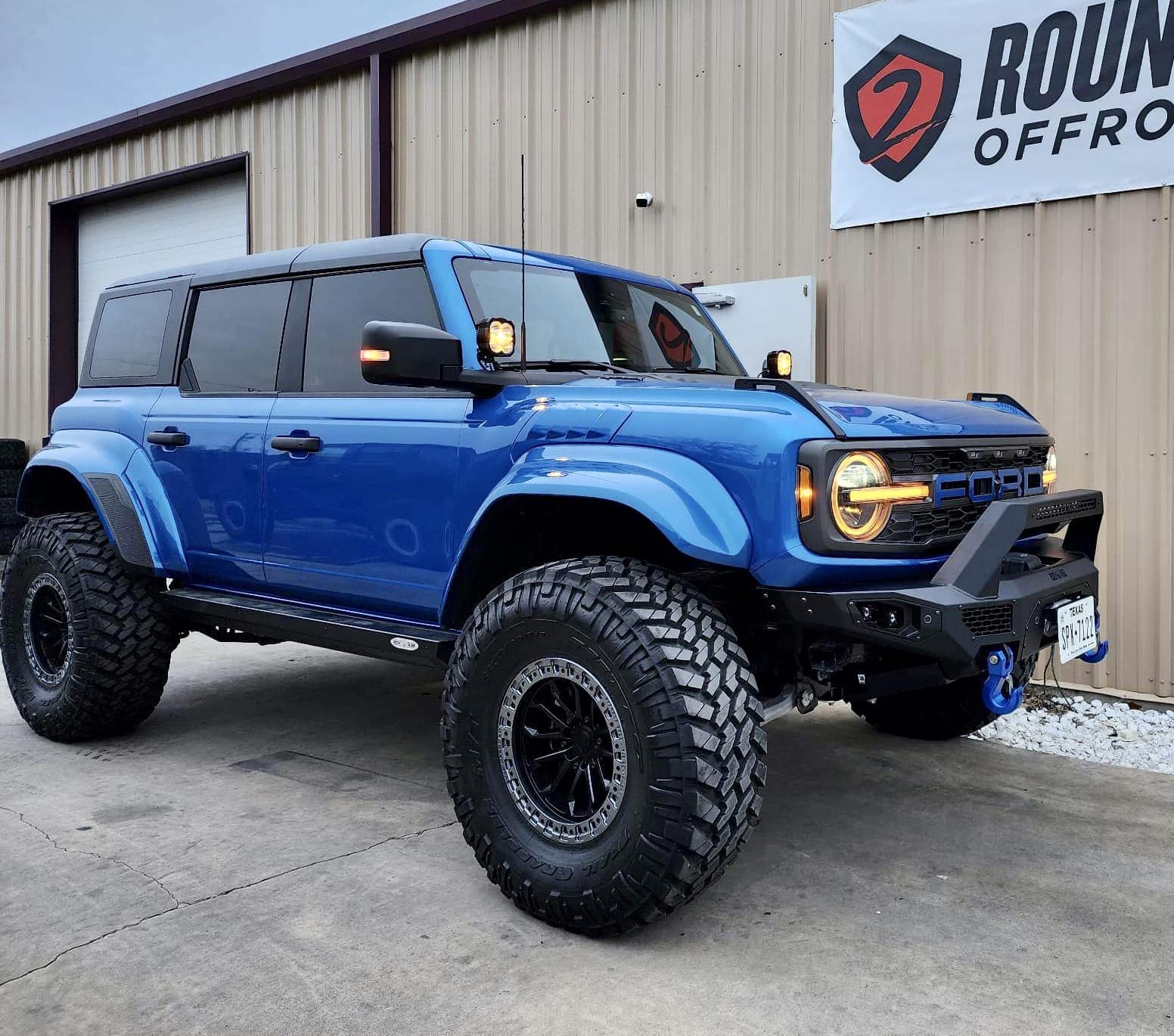 Velocity Blue Bronco Raptor on RPG perch collar lift, 38's and painted